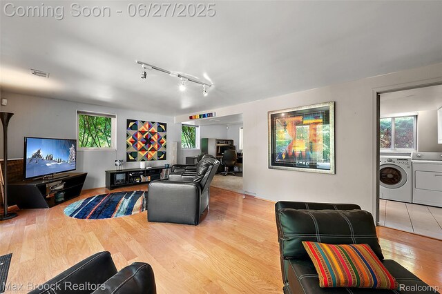 7189 Lindenmere Dr, Bloomfield Hills, MI 48301 - living area with washing machine and clothes dryer, wood finished floors, and rail lighting