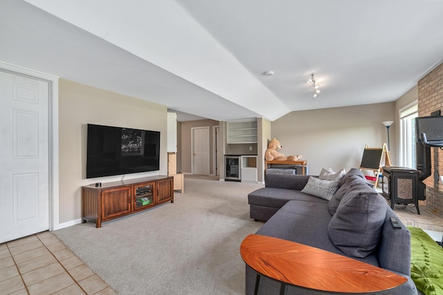 7639 Dunross Dr, Portage, MI 49024 - living area with light tile patterned flooring, light carpet, vaulted ceiling, beverage cooler, and a fireplace