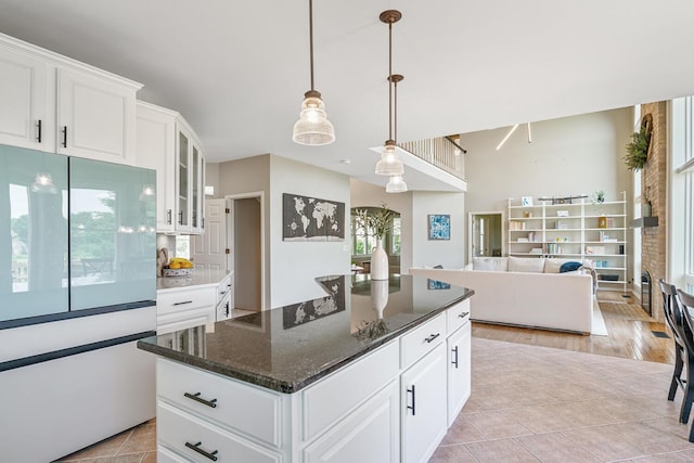 7639 Dunross Dr, Portage, MI 49024 - kitchen with freestanding refrigerator, glass insert cabinets, white cabinetry, decorative light fixtures, and open floor plan
