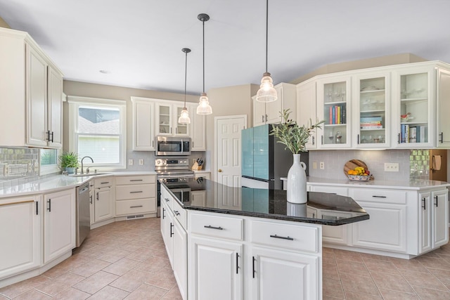 7639 Dunross Dr, Portage, MI 49024 - kitchen with stainless steel appliances, backsplash, a kitchen island, and white cabinets