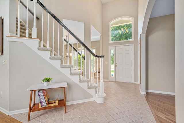 7639 Dunross Dr, Portage, MI 49024 - entrance foyer with a towering ceiling, stairway, arched walkways, and tile patterned floors