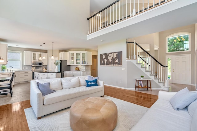 7639 Dunross Dr, Portage, MI 49024 - living room with a high ceiling, light wood-style floors, and stairs