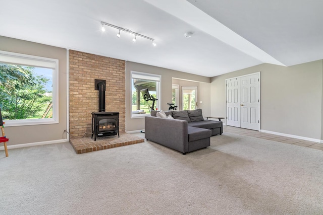 7639 Dunross Dr, Portage, MI 49024 - carpeted living room featuring a wood stove, plenty of natural light, and track lighting