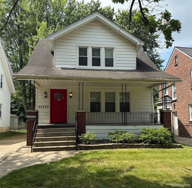 22509 Gregory St, Dearborn, MI 48124 - bungalow with a porch, roof with shingles, and a front yard