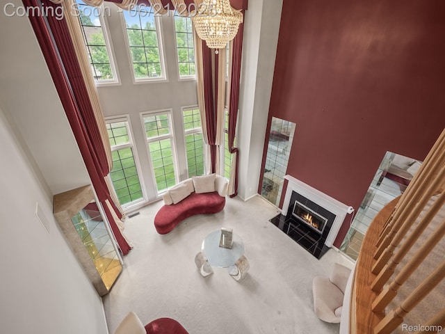 1539 Bartley Ln, Bloomfield Hills, MI 48304 - living room with a towering ceiling, a chandelier, a fireplace with flush hearth, and carpet flooring