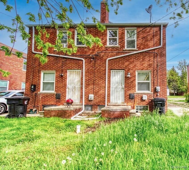 17710 Chester St, Detroit, MI 48224 - back of property featuring brick siding, a chimney, and a lawn