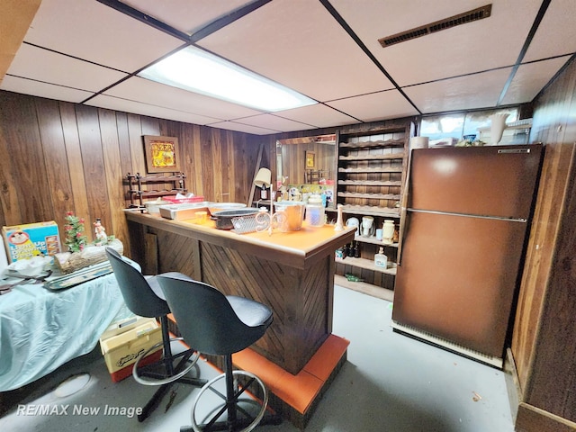 504 Abingdon St, Chesaning, MI 48616 - bar with refrigerator, wooden walls, concrete floors, and a paneled ceiling