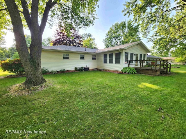 504 Abingdon St, Chesaning, MI 48616 - rear view of house with a wooden deck and a lawn