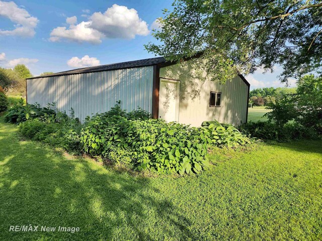 504 Abingdon St, Chesaning, MI 48616 - view of side of home with an outbuilding, an outdoor structure, and a lawn