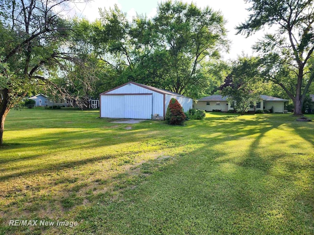 504 Abingdon St, Chesaning, MI 48616 - view of green lawn featuring an outbuilding and a detached garage