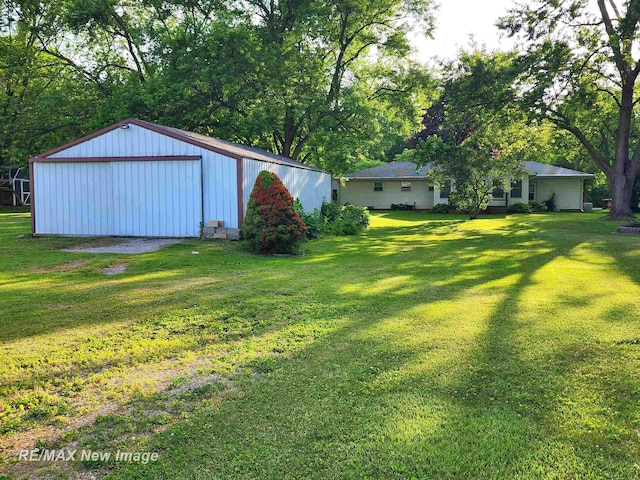 504 Abingdon St, Chesaning, MI 48616 - view of green lawn with an outbuilding, a garage, and an outdoor structure