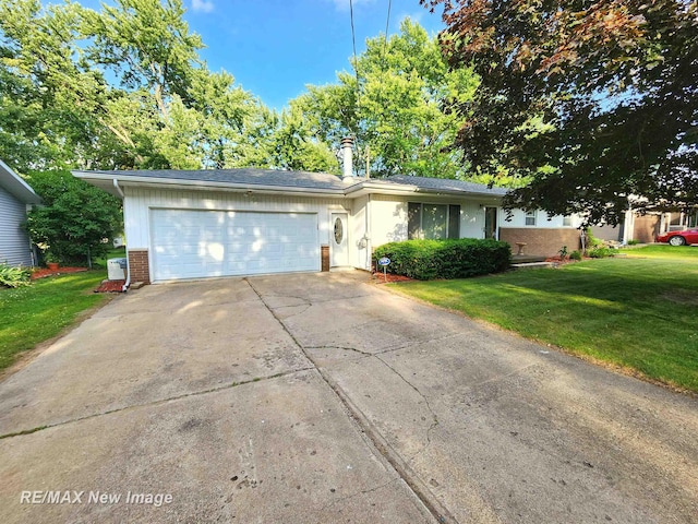 504 Abingdon St, Chesaning, MI 48616 - view of front of property featuring a front yard, a garage, brick siding, concrete driveway, and a chimney