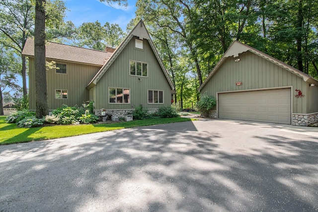 5254 Morrison St, Newaygo, MI 49337 - view of front facade featuring a garage, roof with shingles, an outdoor structure, and driveway