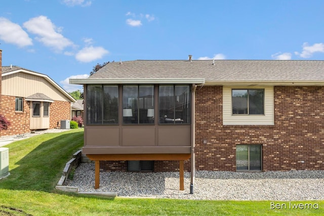 679 Waterview Ct SW, Grandville, MI 49418 - rear view of house with a sunroom, brick siding, a lawn, and roof with shingles