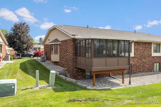 679 Waterview Ct SW, Grandville, MI 49418 - rear view of house with brick siding, a yard, a sunroom, and a shingled roof