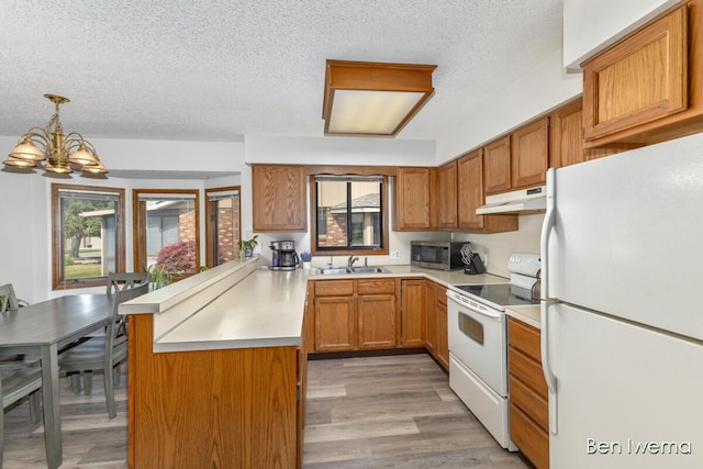 679 Waterview Ct SW, Grandville, MI 49418 - kitchen featuring white appliances, under cabinet range hood, a peninsula, a textured ceiling, and light countertops