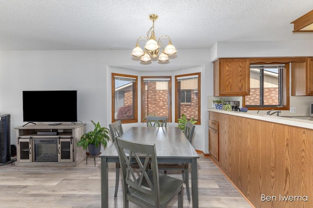 679 Waterview Ct SW, Grandville, MI 49418 - dining room featuring a chandelier, light wood-style flooring, and a textured ceiling