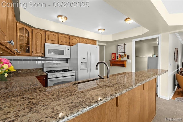 43603 Arlington Rd, Canton, MI 48187 - kitchen with white appliances, brown cabinets, light stone counters, decorative backsplash, and glass insert cabinets
