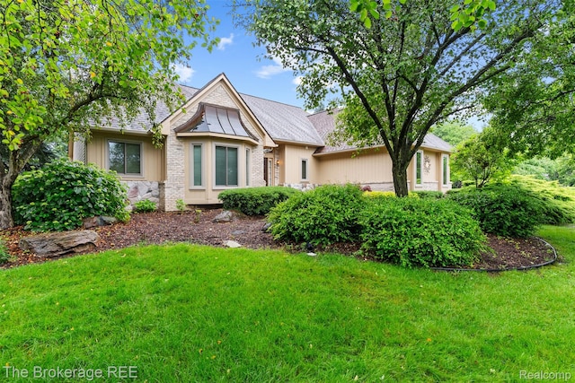 2048 Mayfair Dr, White Lake, MI 48383 - tudor house featuring a front yard and stone siding