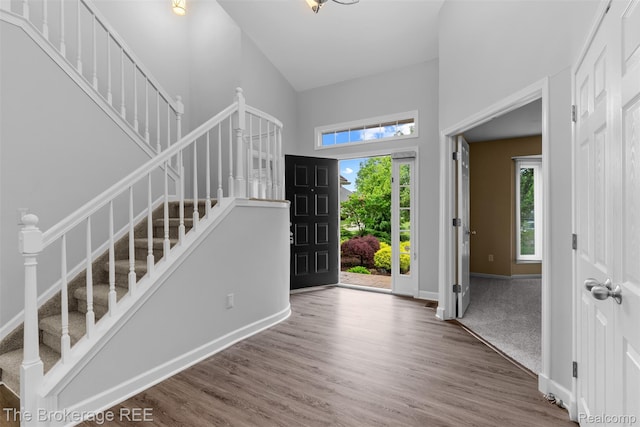 2048 Mayfair Dr, White Lake, MI 48383 - entryway featuring stairway, a towering ceiling, plenty of natural light, and wood finished floors