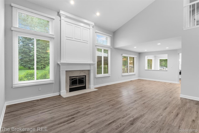 2048 Mayfair Dr, White Lake, MI 48383 - unfurnished living room with a fireplace, wood finished floors, high vaulted ceiling, and recessed lighting