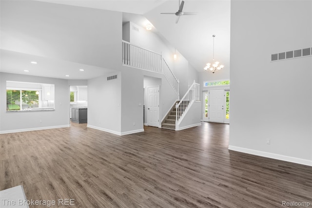 2048 Mayfair Dr, White Lake, MI 48383 - unfurnished living room featuring high vaulted ceiling, stairway, wood finished floors, a chandelier, and recessed lighting