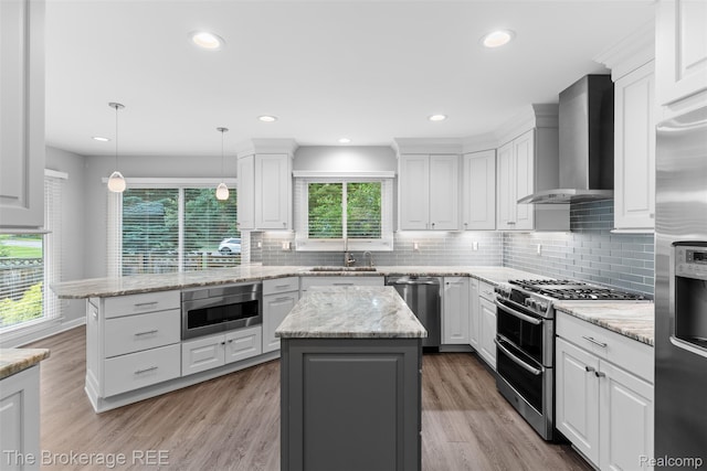 2048 Mayfair Dr, White Lake, MI 48383 - kitchen with appliances with stainless steel finishes, wall chimney range hood, white cabinets, a center island, and recessed lighting