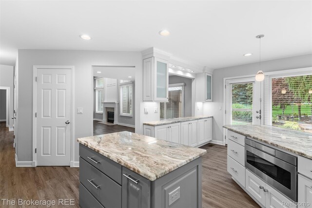 2048 Mayfair Dr, White Lake, MI 48383 - kitchen with stainless steel microwave, white cabinets, glass insert cabinets, dark wood-style flooring, and recessed lighting