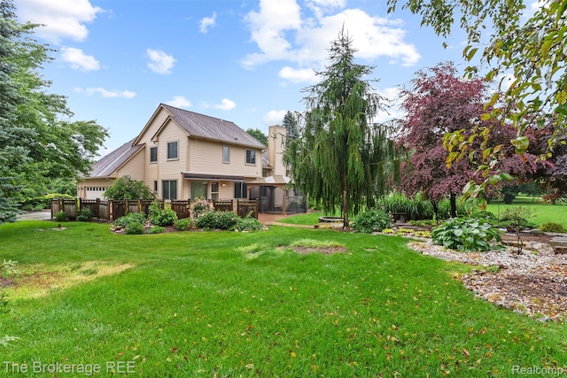 2048 Mayfair Dr, White Lake, MI 48383 - back of property with a yard, a garage, and a deck