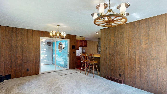 5724 E Townline Rd, Birch Run, MI 48415 - carpeted dining room featuring a chandelier and wooden walls