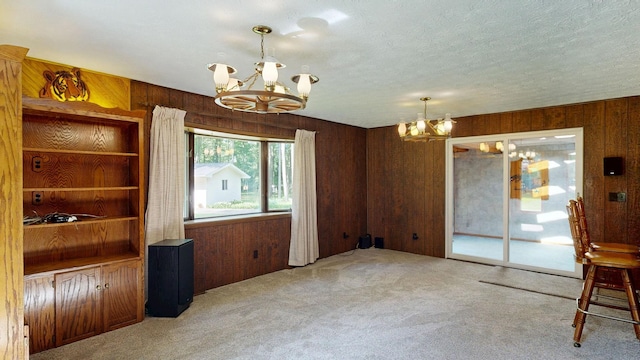 5724 E Townline Rd, Birch Run, MI 48415 - unfurnished dining area featuring a chandelier, carpet, wooden walls, and a textured ceiling