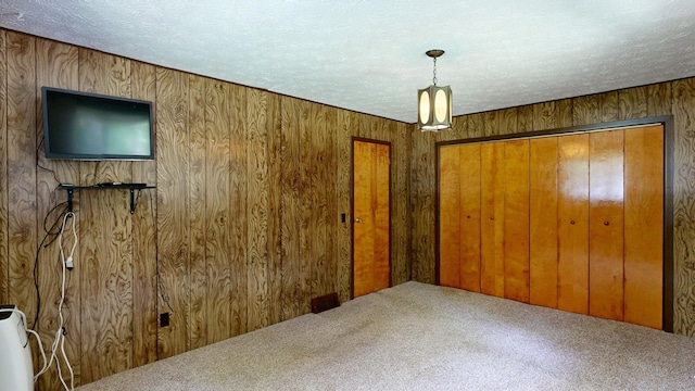 5724 E Townline Rd, Birch Run, MI 48415 - carpeted bedroom featuring wood walls, a closet, and a textured ceiling
