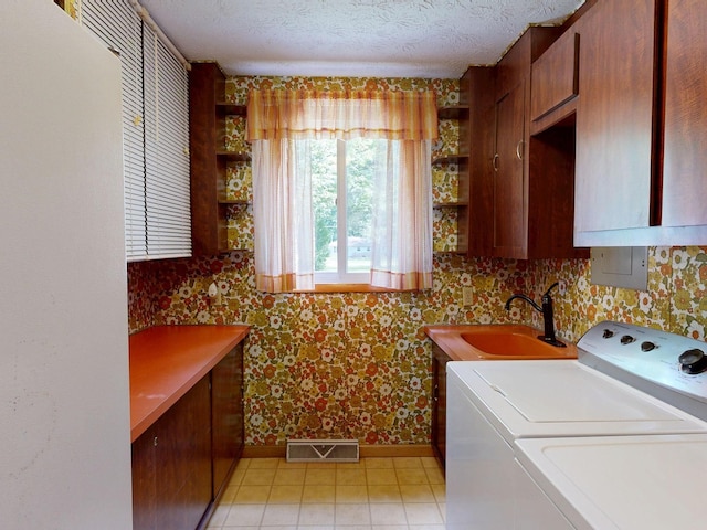 5724 E Townline Rd, Birch Run, MI 48415 - laundry room with washing machine and dryer, cabinet space, wallpapered walls, and a textured ceiling