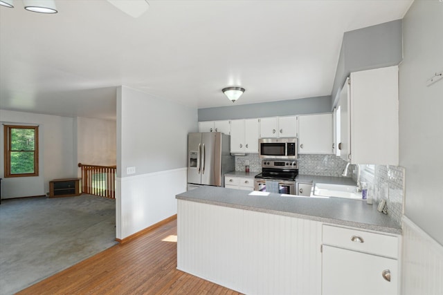 15730 Cedar Springs Ave NE, Cedar Springs, MI 49319 - kitchen featuring stainless steel appliances, tasteful backsplash, a peninsula, light countertops, and white cabinets