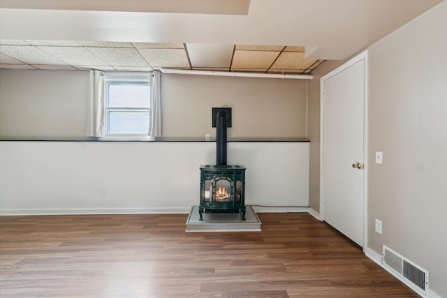 15730 Cedar Springs Ave NE, Cedar Springs, MI 49319 - below grade area featuring wood finished floors, a wood stove, and a paneled ceiling