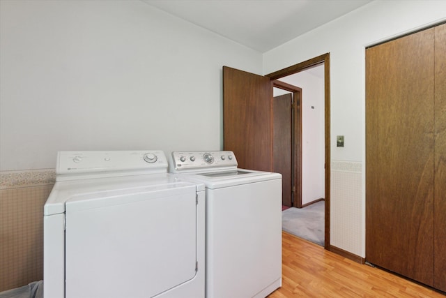 15730 Cedar Springs Ave NE, Cedar Springs, MI 49319 - washroom with separate washer and dryer, light wood-type flooring, and a wainscoted wall