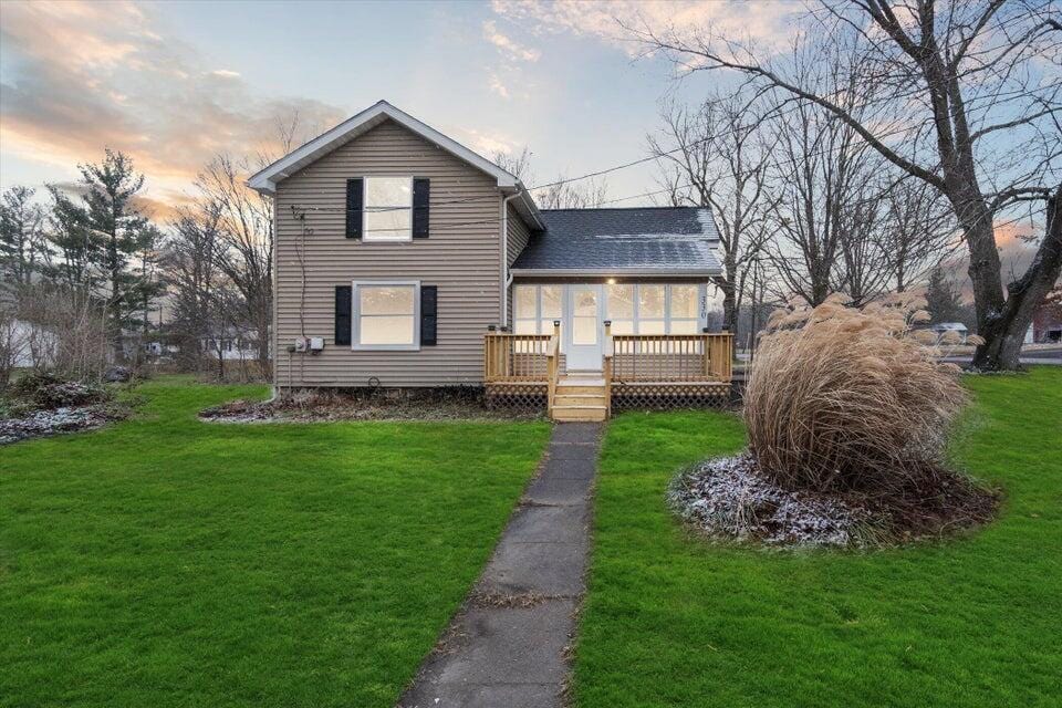 330 E Main, Hanover, MI 49241 - view of front facade featuring a deck, a lawn, and roof with shingles