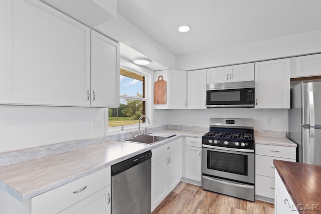 6027 Onsted Hwy, Onsted, MI 49265 - kitchen with stainless steel appliances, white cabinets, wood counters, light wood-style floors, and recessed lighting