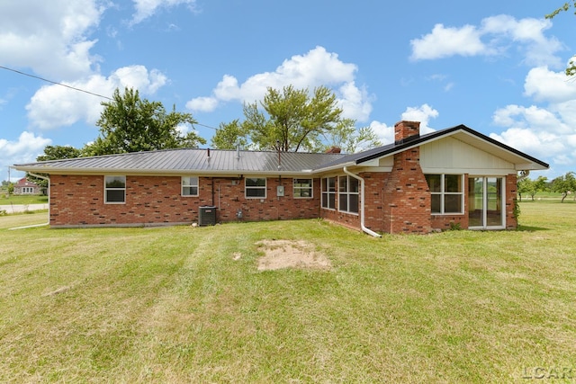 6027 Onsted Hwy, Onsted, MI 49265 - rear view of property with a chimney, brick siding, a yard, and a metal roof