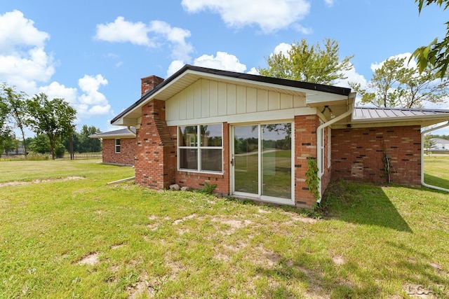 6027 Onsted Hwy, Onsted, MI 49265 - rear view of property with a chimney, a yard, brick siding, and a standing seam roof