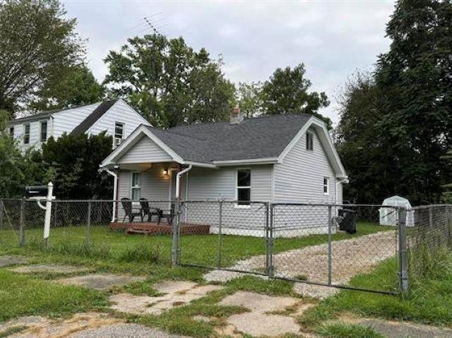 3148 Woodrow Ave, Flint, MI 48506 - view of side of home with a gate, a chimney, and a porch