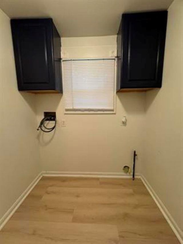 3148 Woodrow Ave, Flint, MI 48506 - laundry room with light wood finished floors, washer hookup, and cabinet space
