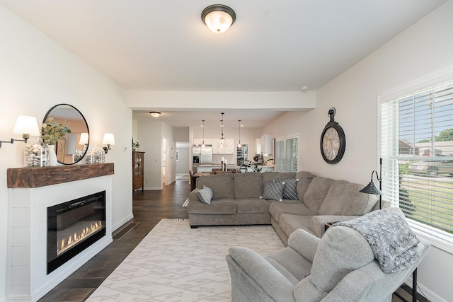 8015 Bloomer St, Carson City, MI 48811 - living room with plenty of natural light, dark wood finished floors, a glass covered fireplace, and a chandelier