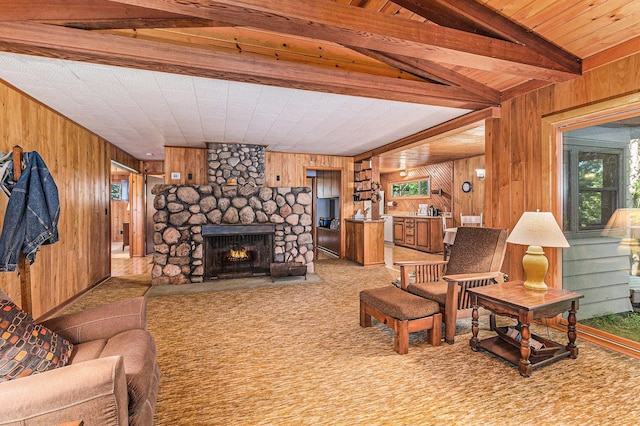 6253 Loggers Ln, Ludington, MI 49431 - living area with wood walls, a fireplace, light carpet, and beam ceiling