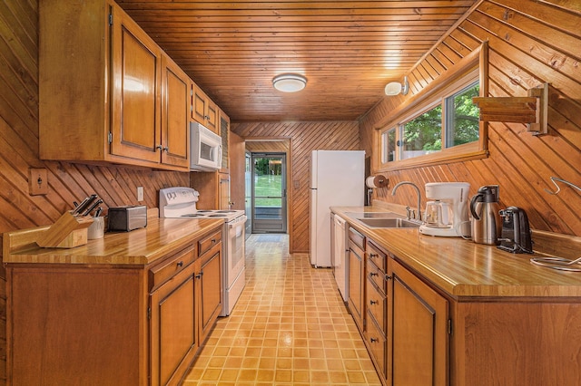 6253 Loggers Ln, Ludington, MI 49431 - kitchen with white appliances, wood walls, wooden counters, brown cabinets, and wooden ceiling