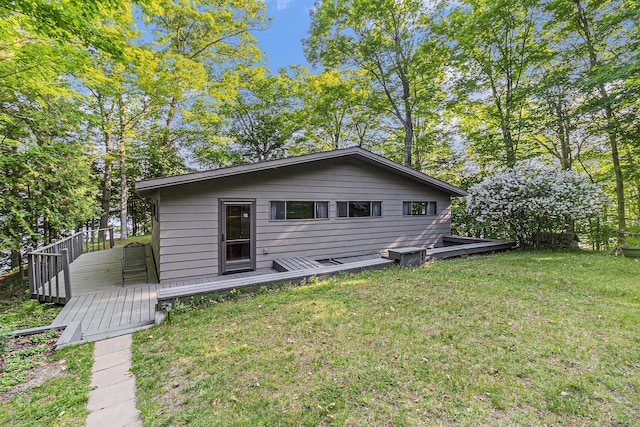 6253 Loggers Ln, Ludington, MI 49431 - rear view of house featuring a wooden deck and a lawn