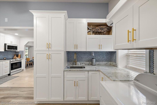 2231 N St, Milford, MI 48380 - kitchen with washer / clothes dryer, stainless steel electric range, white cabinetry, decorative backsplash, and recessed lighting