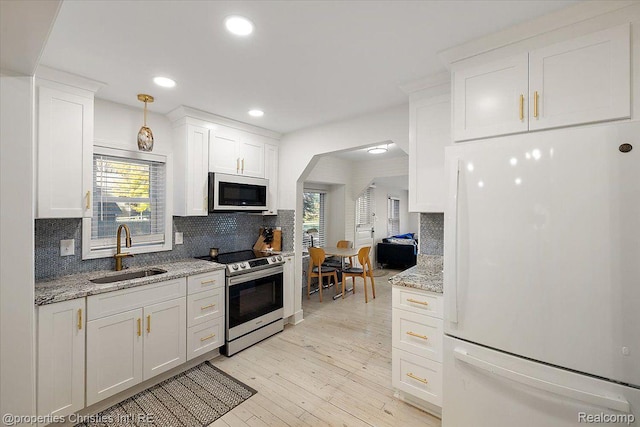 2231 N St, Milford, MI 48380 - kitchen with freestanding refrigerator, electric range, arched walkways, backsplash, and recessed lighting