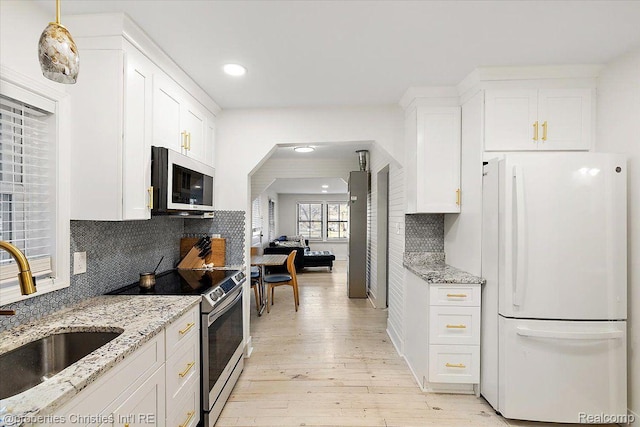 2231 N St, Milford, MI 48380 - kitchen with freestanding refrigerator, stainless steel electric range oven, light wood-style flooring, recessed lighting, and white cabinets