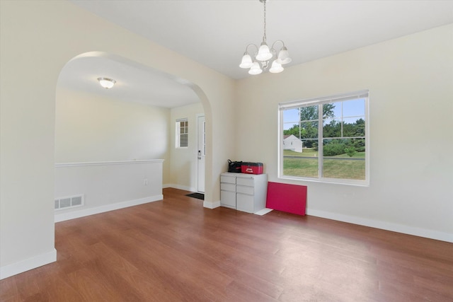 14704 Crescent Meadows Dr, Cedar Springs, MI 49319 - empty room with arched walkways, wood finished floors, and a chandelier